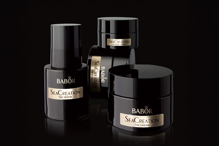 Vier schwarze BABOR SeaCreation Produkte nebeneinander und aufeinander gestapelt